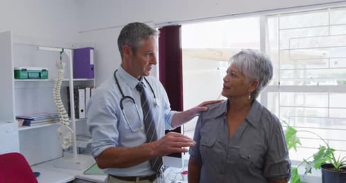 Doctor Consulting with Senior Woman in Clinic