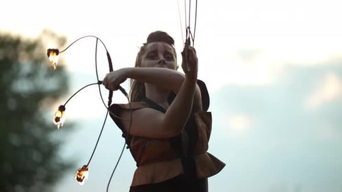 Performer Skillfully Manipulates Fire Sticks