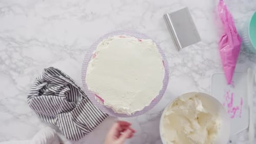 Flat lay. Step by step. Frosting round funfetti cake with white italian buttercream frosting