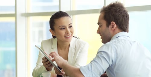 Business Colleagues Brainstorming with Tablet in Bright Office