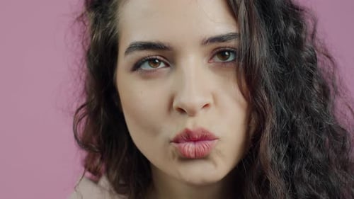 Portrait en gros plan d'une fille enjouée faisant des grimaces et souriant s'amusant à regarder la caméra contre