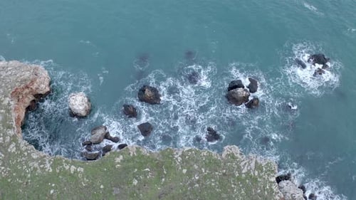 Dramatic Aerial View of Rocky Coastline and Ocean Waves