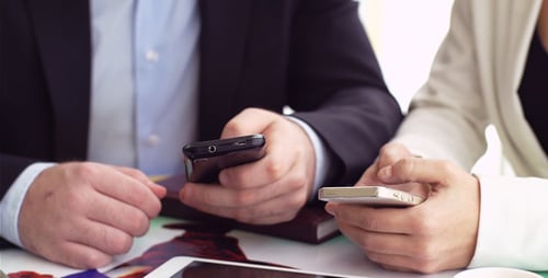 Professionals Using Mobile Technology in Modern Workplace