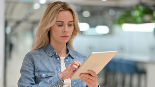 Blonde Woman Using Tablet Device in Workplace
