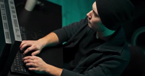 Young Adult Typing on Computer in Dark Room