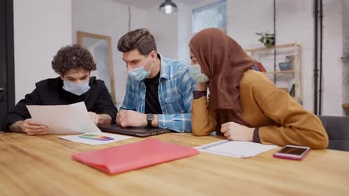 People in Masks Collaborate in an Office