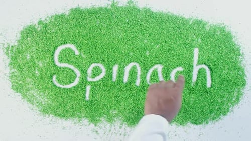 Handschreibt auf grünem Spinat