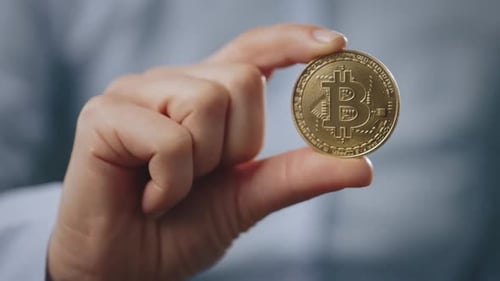 Close Up of Man Showing Physical Bitcoin Coin