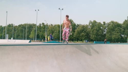 Shirtless Young Adult Skateboarding on Concrete Ramp