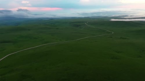 Luftaufnahme auf die wunderschöne Sommerlandschaft mit Landstraße und grünen Feldern