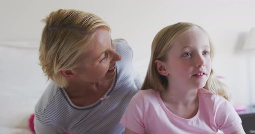 Front view of Caucasian woman cuddling her daughter