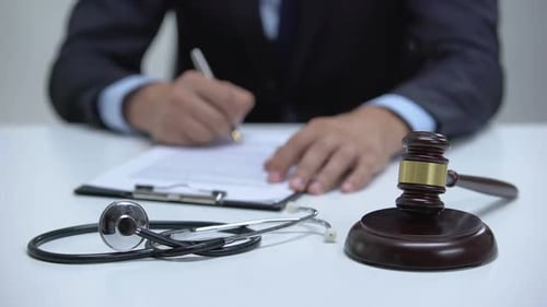 Gavel Stethoscope and Paperwork on a Desk