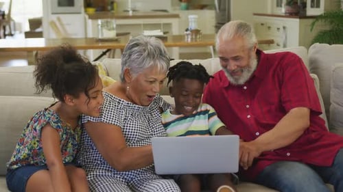 Happy Family Using Laptop Together on Couch