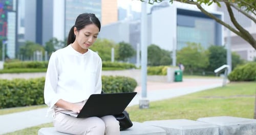 Woman Works on Laptop in Urban Park