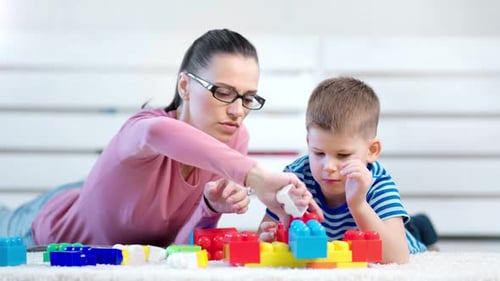 Woman and Child Playing with Building Blocks Indoors