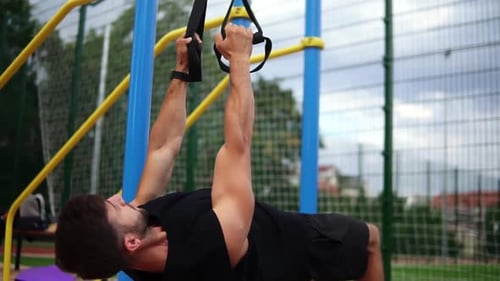 Muscular Man Doing Suspension Training Outdoors