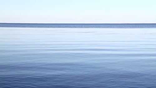 Waves and ripples run on blue water surface