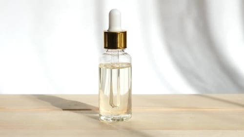 Elegant Serum Bottle with Dropper on Wooden Surface
