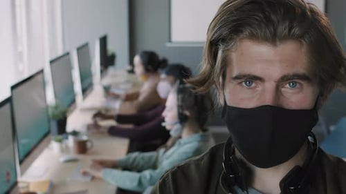 Operador de call center posando com máscara facial