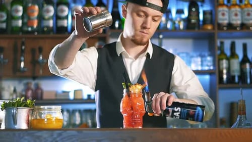 Bartender Burning a Cocktail Garnish with a Torch