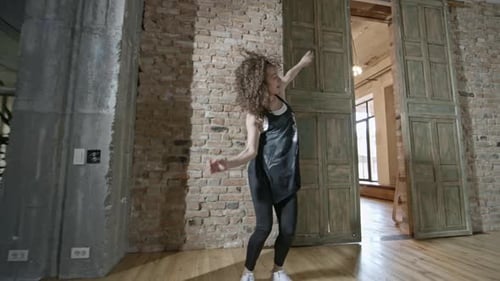 Energetic Young Woman Dancing in Urban Studio