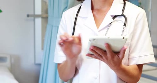 Doctor Using Tablet in Cheerful Hospital Room