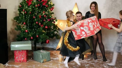 Little Girls Running in the Room and Taking Presents From Underneath the Christmas Tree Giving Them