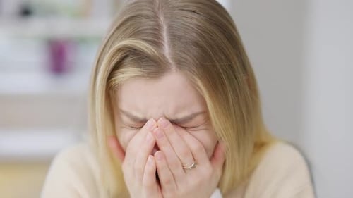 Blonde Woman Crying with Hands Covering Face
