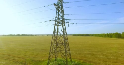 Vertikaler Bewegungsflug in der Nähe von Hochspannungs-Strommasten und Stromleitungen in Grün und Gelb