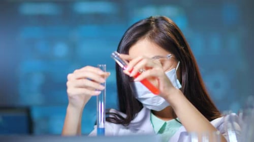 Young Scientist Mixing Chemicals in Laboratory Test Tubes