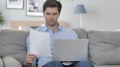 Young Adult Man Working From Home On Laptop