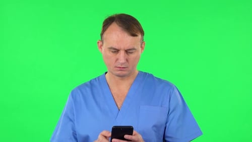 Happy Medical Man Texting on Him Phone. Green Screen
