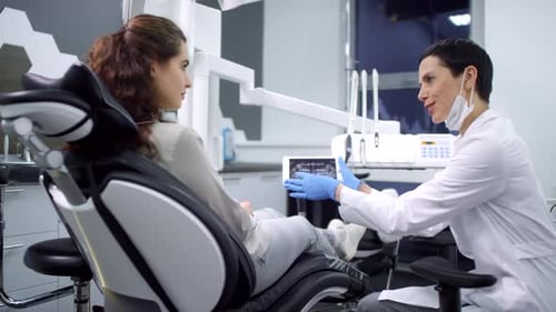 Female Dentist Showing Jaw X-Ray to Patient