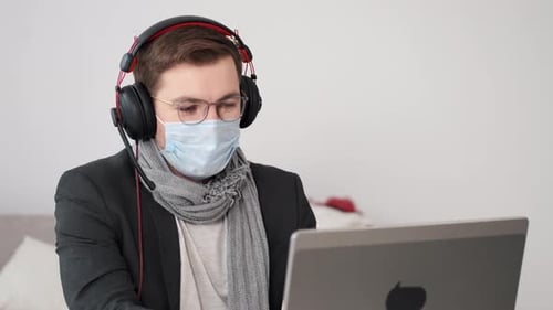 Man Working on Laptop at Home with Mask