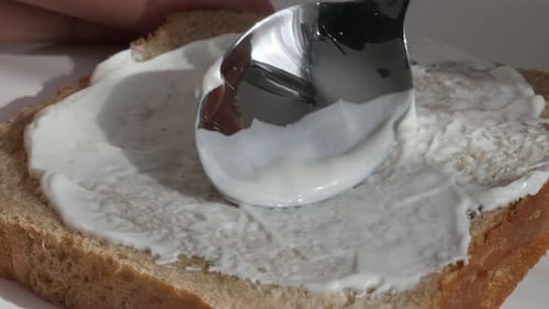 Cheese spreading over toast bread close-up 4K footage