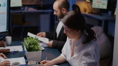 Team of Adults Collaborating in Evening Office