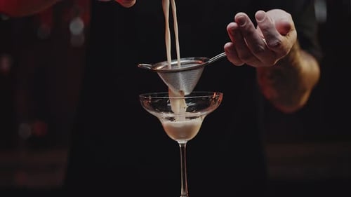 Bartender Straining a Cocktail into a Glass