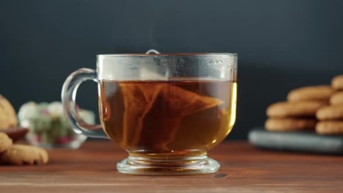 Frisch gebrühte Tasse schwarzen Tees auf einem Holztisch Teezeremonie-Prozess Fast Food Wasser gießen