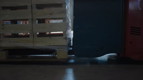 Pallet Jack Lifting Pallet in Warehouse