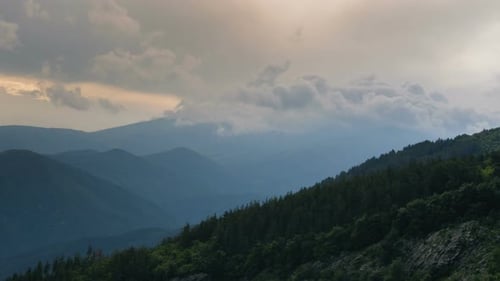 Time lapse of Mountain Hills with Fast Fluffy Clouds and Sunset