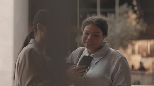 Two Female Colleagues Chatting in Department Store