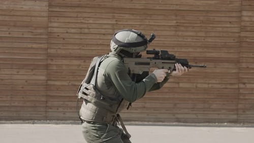 Slow motion of soldier shooting automatic rifle in a range