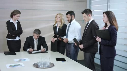 Business Team Reviewing Documents in Bright Office