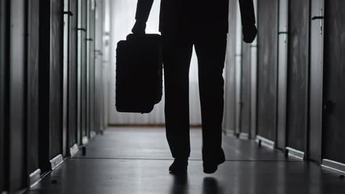 Silhouette of Businessman Leaving Hotel