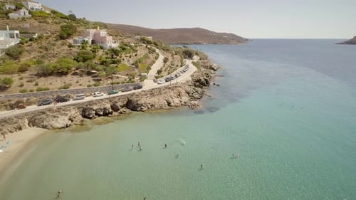 Aerial view of people swimming on beach, Alithini, Syros island in Greece.
