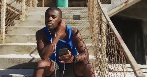 Man With Phone Relaxing on Steps Outside