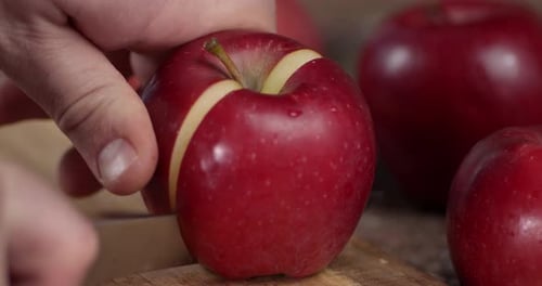Schneide den roten reifen Apfel ab.