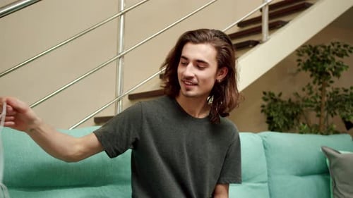 Man Removes Mask and Smiles in Living Room
