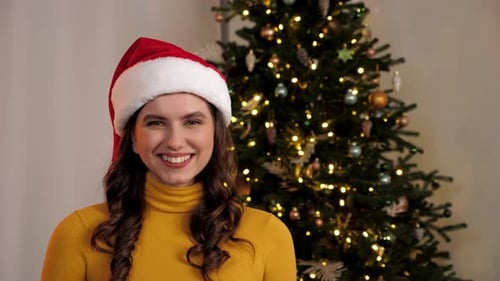 Festive Woman with Santa Hat Smiles at Camera