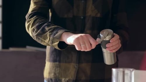 Woman Grinding Coffee Beans with Manual Coffee Grinder